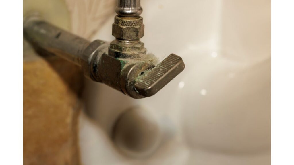 Leaking plumbing shutoff valve with mineral buildup in an Arizona home
