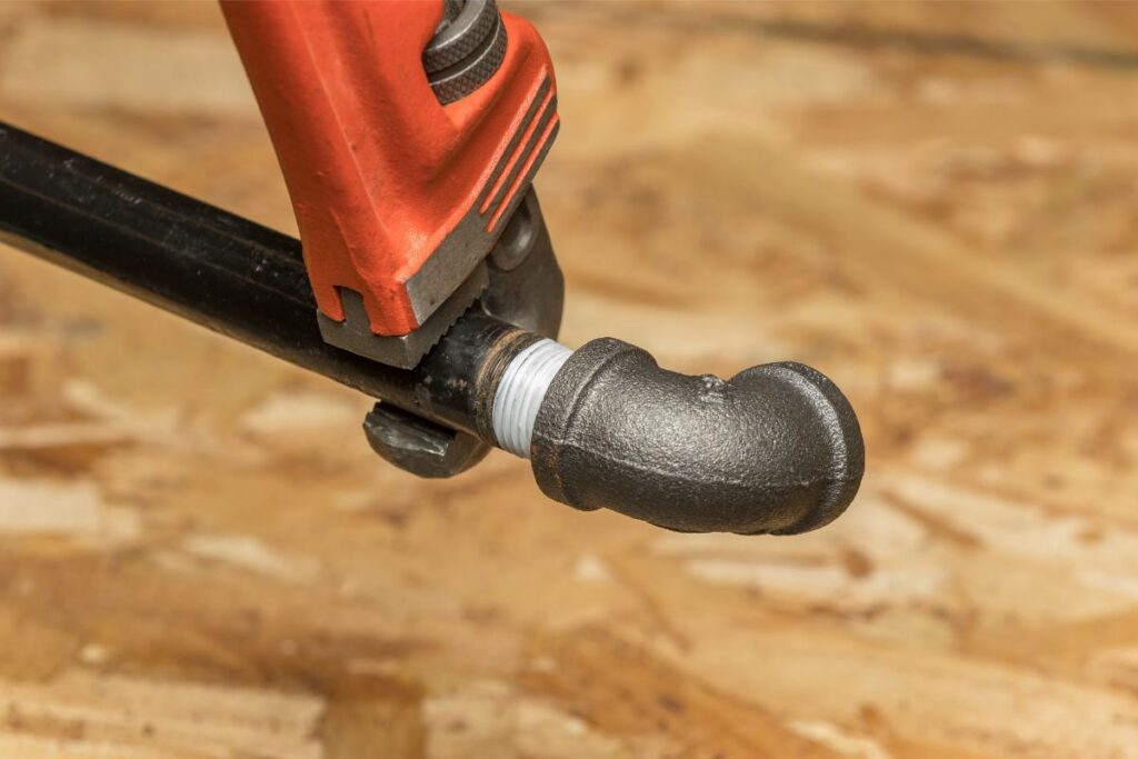 Gas Plumbing Services Pipe Patrol AZ plumber installing threaded black iron gas pipe fitting